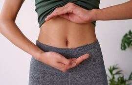 Mujer señala su abdomen.