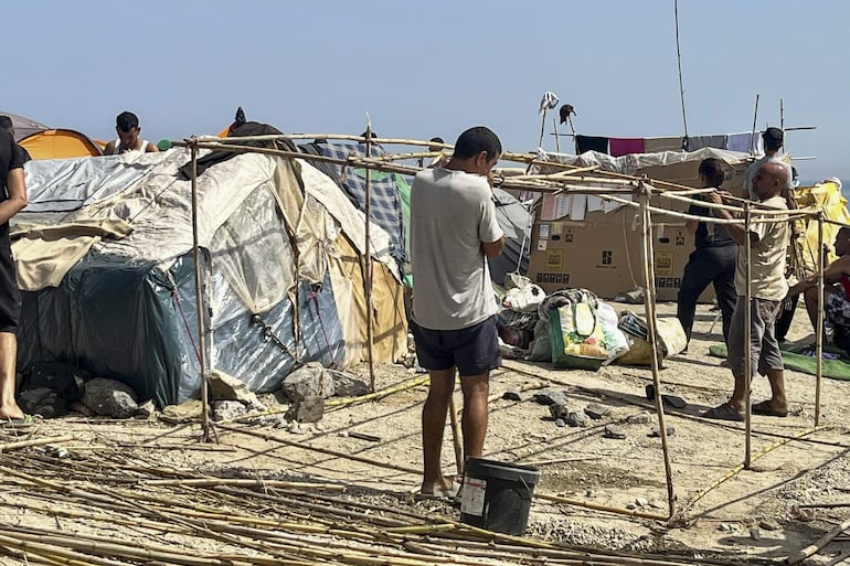 Continúan las construcciones de chozas a base de cañas, ramas, cartones y plástico en el asentamiento de la playa del Trampolín. EFE/ Reduán