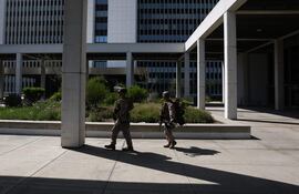 Miembros del Cuerpo de Marines de los Estados Unidos (USMC) llevan rifles alrededor del exterior del edificio federal Wilshire, en Los Ángeles.