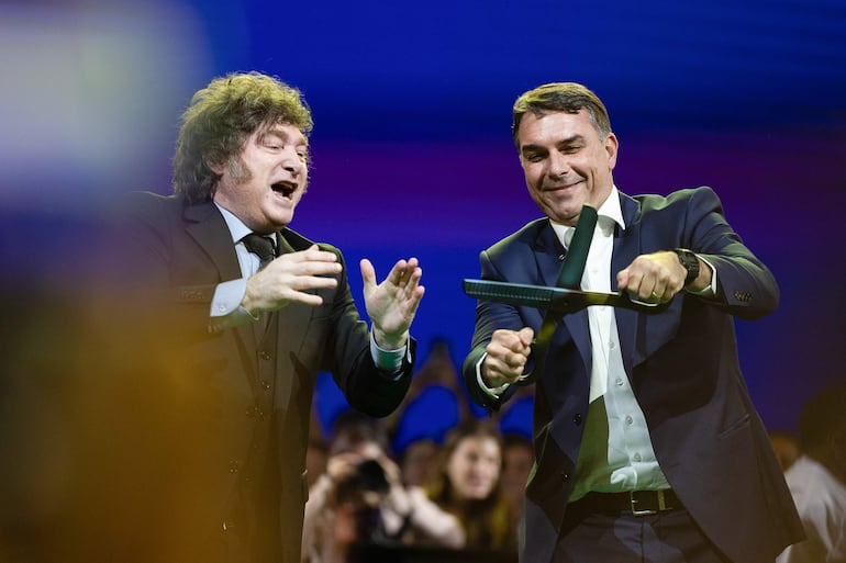 El senador de Brasil Flávio Bolsonaro (d) reacciona junto al presidente de Argentina, Javier Milei, durante la convención nacional del Partido Liberal de Brasil (PL) este sábado, en São Paulo (Brasil). El PL que lidera el expresidente Jair Bolsonaro, dio inicio a la convención para proclamar a su hijo mayor, Flávio, como candidato presidencial para las elecciones del próximo octubre.