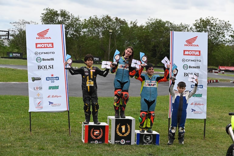 Los protagonistas de la categoría GP Junior, celebran en el podio con sus respectivos trofeos.