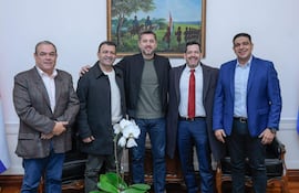 Pedro Alliana y los diputados Roussillón, del Puerto, Latorre y Meza, sonrientes y vestidos en semi-formal, en un ambiente gubernamental.