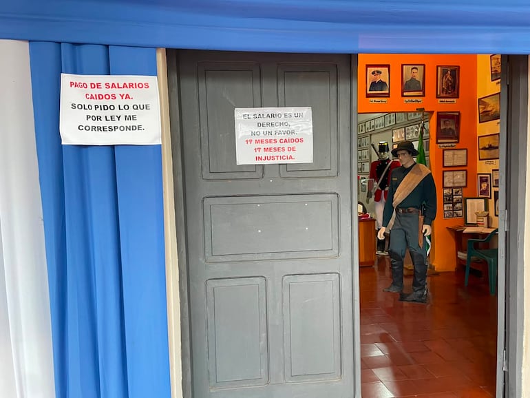 Carteles de protesta por falta de pago a la guía del Museo de la Victoria en Encarnación.