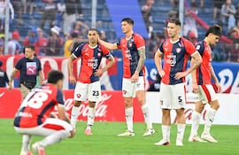 Víctor Gustavo Velázquez Kururu y Jorge Morel de Cerro Porteño muestran expresiones de desánimo en la cancha, rodeados de un ambiente vibrante.
