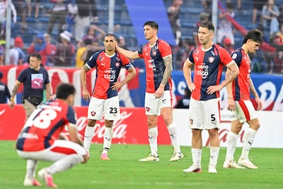 Víctor Gustavo Velázquez Kururu y Jorge Morel de Cerro Porteño muestran expresiones de desánimo en la cancha, rodeados de un ambiente vibrante.