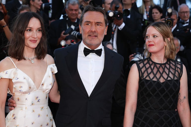 La actriz francesa Anais Demoustier, el actor francés Gilles Lellouche y la actriz francesa Madeleine Baudot llegan a la ceremonia de apertura y a la proyección de la película "La Venus electrique" (El beso eléctrico) en la 79ª edición del Festival de Cine de Cannes. (Valery HACHE / AFP)