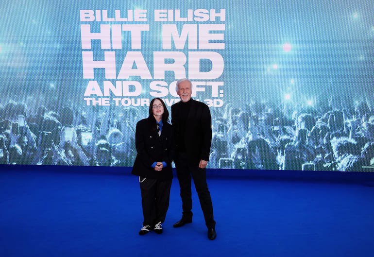 La cantante estadounidense Billie Eilish con el director de cine estadounidense James Cameron en la alfombra azul del estreno en el Reino Unido de la película "Hit Me Hard and Soft: The Tour (Live in 3D)". (EFE/EPA/ANDY RAIN)
