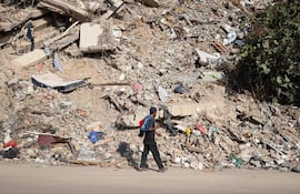 Una persona camina frente a una edificación colapsada por los terremotos en Catia La Mar, Venezuela.
