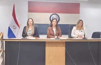Tres juezas sentadas en mesa con micrófonos, Patricia Maidana con blusa negra, Cynthia Marecos en blazer marrón y Cynthia Vega con blusa blanca.