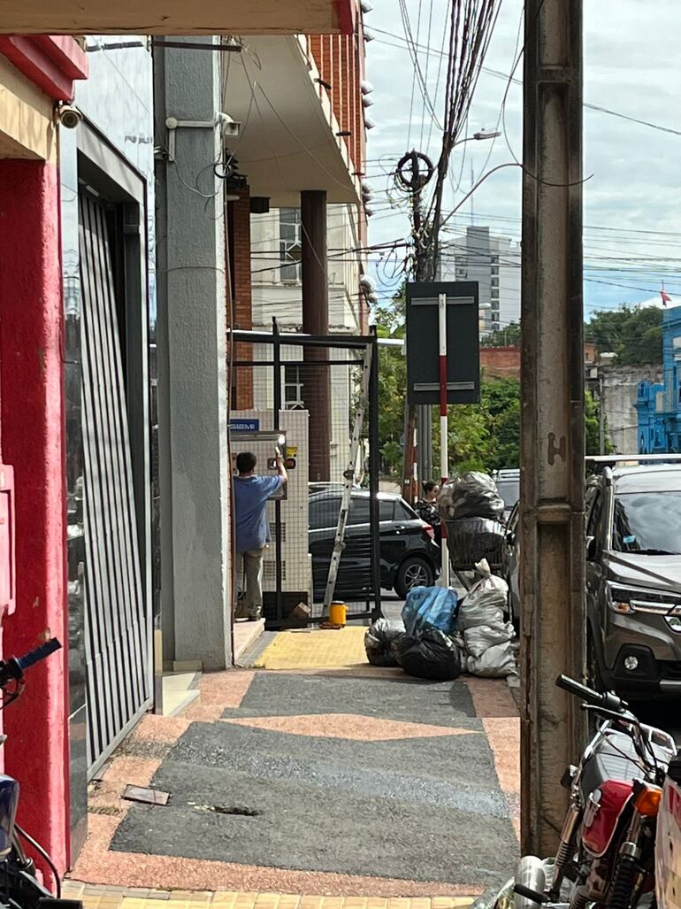 Denuncian que generador y jaula de seguridad invaden vereda e impide paso peatonal en el centro de Asunción.