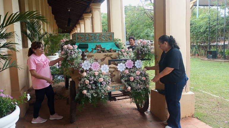 Edith Margarita  Estigarribia, Mirian Britez de Salinas, y Rubén Martínez trabajan en la decoración de la carroza.