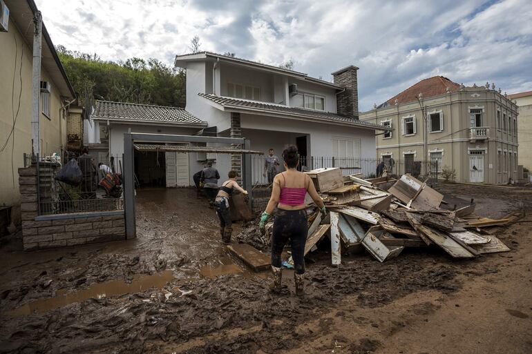 Fotografía cedida por el Gobierno del estado de Rio Grande do Sul que muestra a unas personas que juntan algunos enceres dañados por las torrenciales lluvias, en Muçum, estado de Rio Grande do Sul (Brasil ).