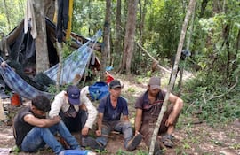 Cuatro de los sospechosos sentados en un sector del improvisado campamento, donde fueron sorprendidos. La Fiscalía pidió prisión para todos, por delito ambiental.