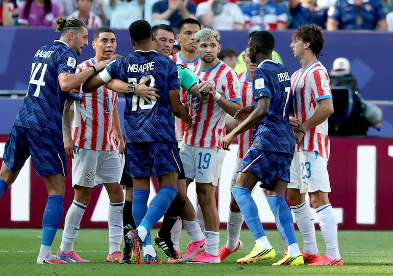 El árbitro Ilgiz Tantashev (de frente) contiene a Kylian Mbappé de Francia durante el partido de los octavos de final de la Copa Mundial de la FIFA 2026 entre Paraguay y Francia, en Filadelfia, EE. UU..