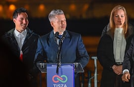 El líder del partido opositor Tisza, Peter Magyar (C) se dirige a sus seguidores tras su aplastante victoria en las elecciones de ayer.