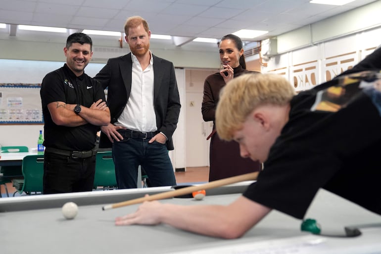 El príncipe Harry y su esposa Meghan observan una partida de billar durante una visita a Epic Partners en Nottingham, en el centro de Inglaterra. Epic Partners brinda apoyo a niños, jóvenes y familias en St Ann’s y Sneinton, Nottingham, a través de actividades juveniles, deporte, mentoría y educación. (Joe Giddens / POOL / AFP)