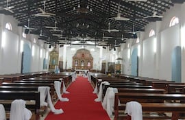 Interior de la Catedral de San Pedro Apóstol, con alto techo, bancos de madera y altar decorado, sin personas presentes.