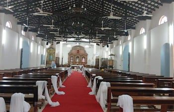 Interior de la Catedral de San Pedro Apóstol, con alto techo, bancos de madera y altar decorado, sin personas presentes.