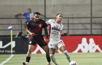 El lateral de Ameliano Jesús Abel Paredes intenta anticipar la maniobra ofensiva del extremo de Nacional Orlando Gaona Lugo.