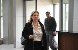 Teresa Sosa Laconich en blusa blanca y chaqueta negra usando un teléfono, en un ambiente moderno y luminoso.