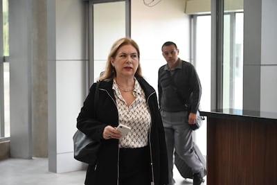 Teresa Sosa Laconich en blusa blanca y chaqueta negra usando un teléfono, en un ambiente moderno y luminoso.