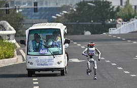 Un robot y sus ingenieros participan en la segunda Beijing E-Town Half Marathon and Humanoid Robot Half Marathon en Beijing el 19 de abril de 2026.