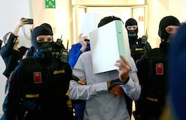 Los acusados ingresan a corte con los rostros cubiertos, este martes en Wiener Neustadt, Austria.
