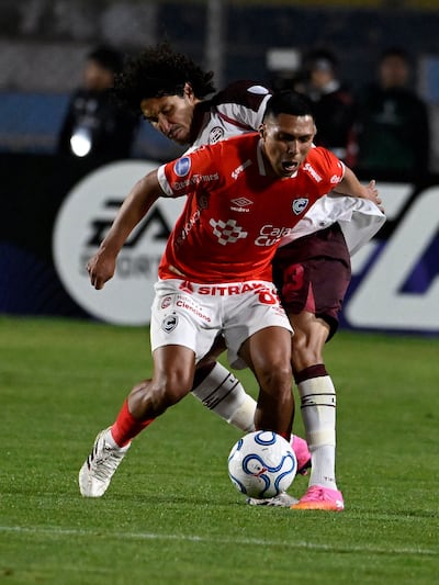 El defensor paraguayo de Lanús, José Canale intenta arrebatarle el esférico al volante ofensivo peruano Gerson Barrero en el duelo de vuelto de los play-offs de la Copa Sudamericana.