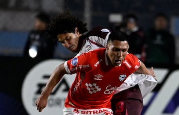 El defensor paraguayo de Lanús, José Canale intenta arrebatarle el esférico al volante ofensivo peruano Gerson Barrero en el duelo de vuelto de los play-offs de la Copa Sudamericana.