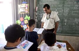 El profesor Toribio Ojeda practica la lectura con sus alumnos del primer grado, en la escuela Sotero Colmán del Bañado Sur, en Asunción.