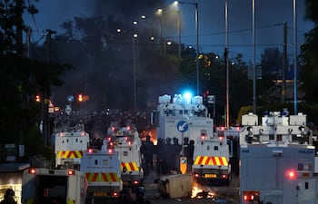 La policía bloquea el paso a los manifestantes (detrás) que conducen a un hotel que se cree que albergaba a inmigrantes, en Antrim Road, Glengormley, al norte de Belfast, Irlanda del Norte