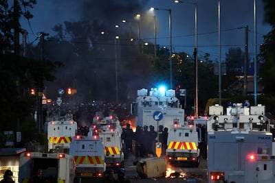 La policía bloquea el paso a los manifestantes (detrás) que conducen a un hotel que se cree que albergaba a inmigrantes, en Antrim Road, Glengormley, al norte de Belfast, Irlanda del Norte