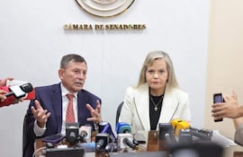El senador Luis Pettengill (ANR, Fuerza Republicana) conversa con periodistas mientras su colega, la senadora Lilian Samaniego de Causa Republicana escucha al legislador.