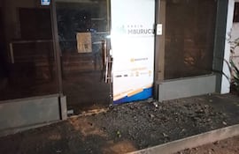 Entrada de Radio Mburu cu con letrero visible, ambiente desolado y escasa iluminación, sin personas presentes.