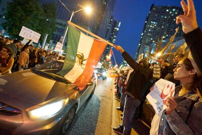 Manifestantes con banderas de Irán protestan en Toronto, Canadá.