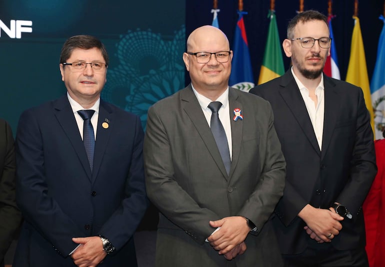 Óscar Lovera en traje gris, Manuel Ochipintti a su lado con blazer oscuro, ambos posan formalmente en un evento oficial.