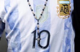 Una persona porta una camiseta de la selección argentina junto a una imagen religiosa durante una peregrinación este sábado, en Luján, provincia de Buenos Aires (Argentina).