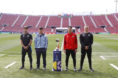 Los entrenadores y capitanes de las selecciones de fútbol Sub 20 de Argentina, Diego Placente, Julio Soler, y de Marruecos Mohamed Ouahbi y Houssam Essadak, posan junto al trofeo del Mundial, en el estadio Nacional de Santiago. 