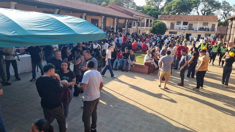 Gran concurrencia de personas conversando en un evento al aire libre, ambiente informal y relajado.