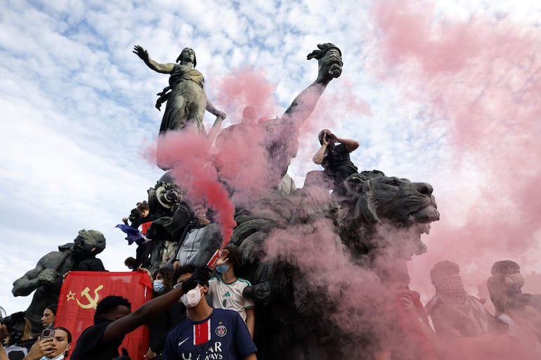 Estudiantes de secundaria y miembros de sindicatos educativos lanzan bengalas de humo rojo al finalizar una jornada nacional de protestas por las condiciones escolares en la plaza de la República de París, Francia