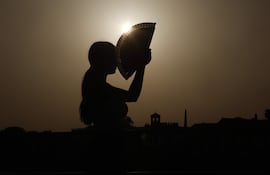 Una persona se abanica al atardecer en una jornada de altas temperatura.