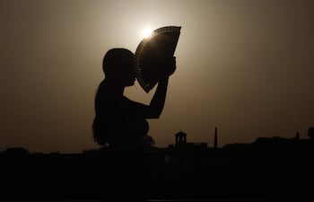 Una persona se abanica al atardecer en una jornada de altas temperatura.