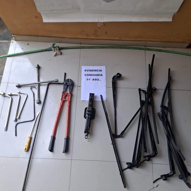 Colección de herramientas de criminalística sobre cerámica con papel que dice 'EVIDENCIA COMISARIA 11° ASU'.