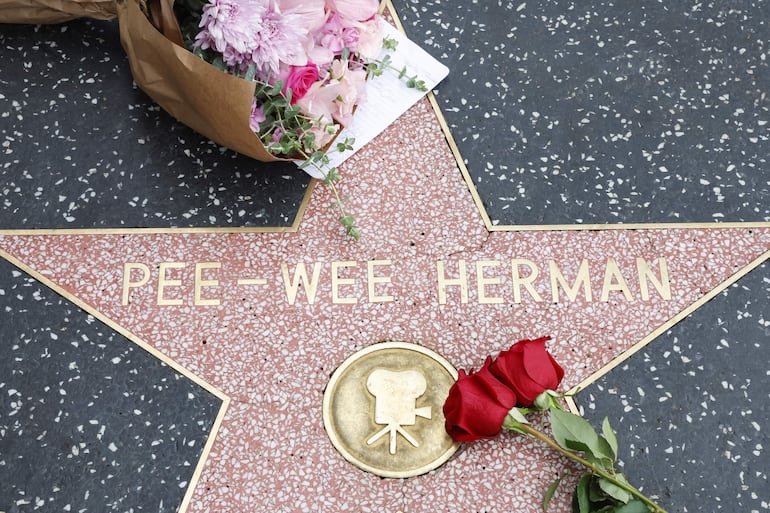 Seguidores dejaron flores junto a la estrella del Paseo de la Fama de Los Ángeles, tras conocerse la noticia del fallecimiento del actor Paul Reubens.