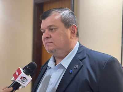 Dionisio Oswaldo Amarilla Guirland, con camisa clara y saco oscuro, mantiene una conversación seria sosteniendo un micrófono en un entorno institucional.