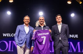 El futbolista francés Antoine Griezmann (c) posando con el dueño y presidente del Orlando City Mark Wilf (i) y el director deportivo Ricardo Moreira este martes, durante su presentación como nuevo jugador, en Orlando (FL, EE.UU.).