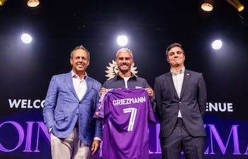 El futbolista francés Antoine Griezmann (c) posando con el dueño y presidente del Orlando City Mark Wilf (i) y el director deportivo Ricardo Moreira este martes, durante su presentación como nuevo jugador, en Orlando (FL, EE.UU.).