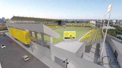 Estructura moderna del estadio con gradas amplias y autos estacionados, predominando los colores amarillos.