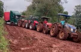 Captura de pantalla del video donde se observa un tren de tractores para sacar un camión cargado de bananas.