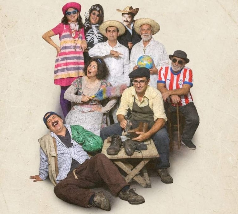 Grupo de nueve personas vestidas de manera colorida, algunas riendo, en un ambiente festivo durante la promoción de una comedia.